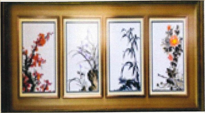 Four tall cross-stitch panels in one gold frame, each a single stem on white: red blossom, white orchid, dark bamboo and an orange flower.