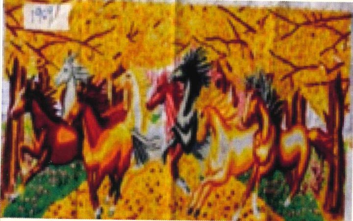 Cross-stitch canvas, photographed unframed, of horses in brown, white and black galloping through a forest of golden leaves.
