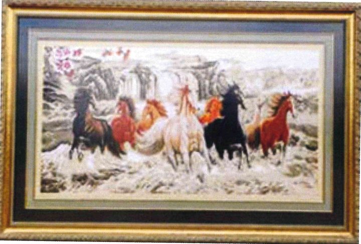 Cross-stitch artwork of a herd of horses charging through white water beneath misty mountains and a waterfall, in a gold frame.
