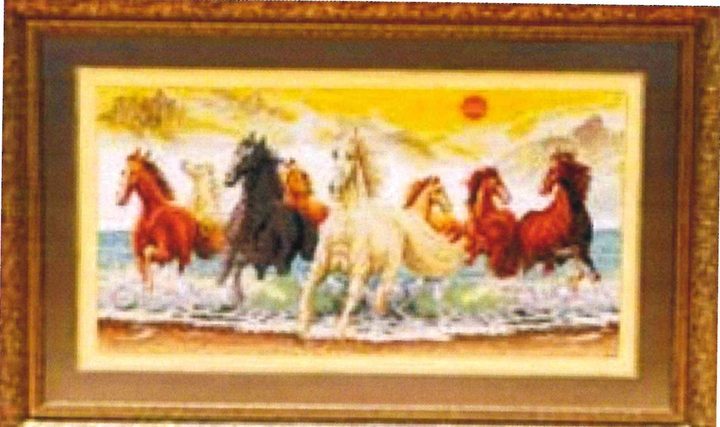 Cross-stitch artwork of eight horses galloping through shallow water beneath a yellow sky and a red sun, in a gold frame.