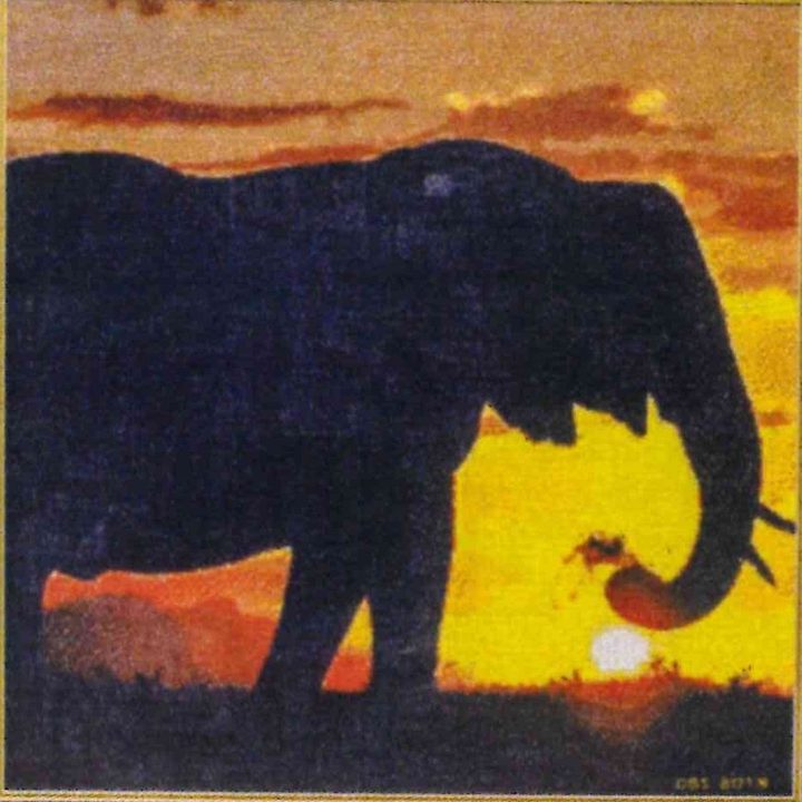 Detail of The Silhouette of Peace: a stitched elephant silhouette against an orange and yellow sunset.